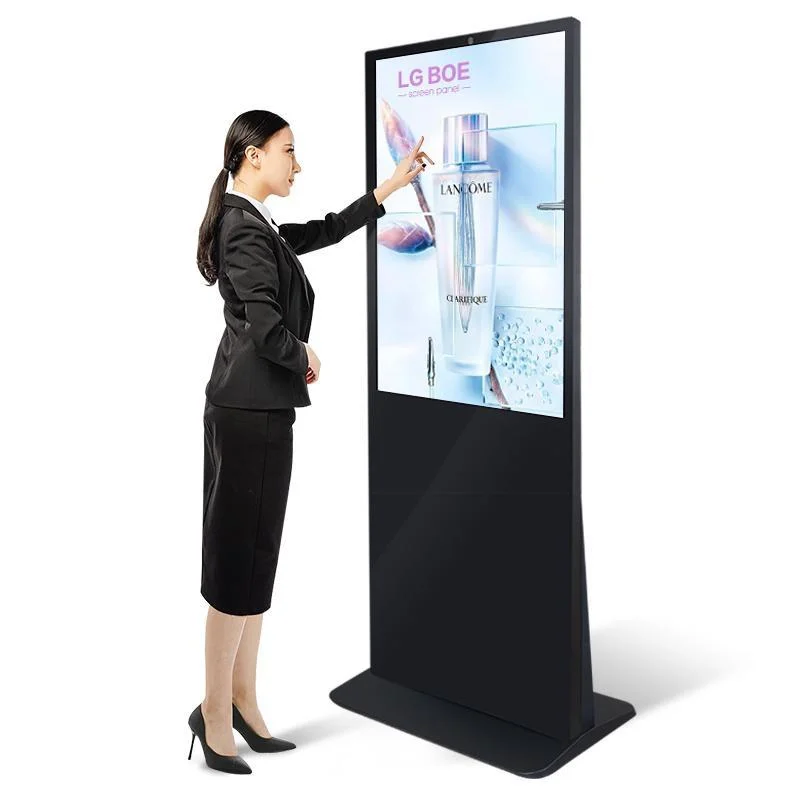 Woman touching a tall floor-standing touchscreen display showing a product campaign
