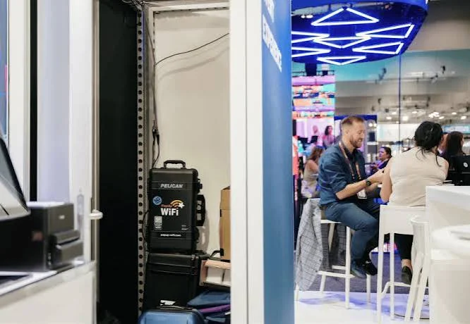 Installing WiFi in Dubai 35 Portable WiFi case stored behind an exhibition stand while visitors chat in a trade show in Dubai