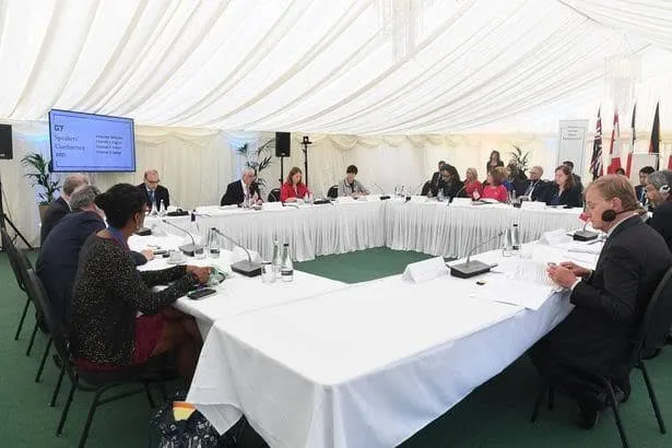 Installing WiFi in Dubai 31 Delegates seated around a large meeting table in a white marquee tent with a screen and microphones