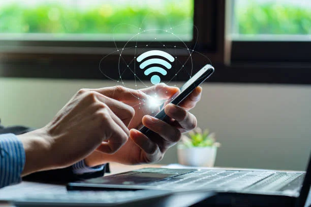 Installing WiFi in Dubai 28 Guest connecting to secure WiFi on a smartphone with a laptop on the desk in Dubai